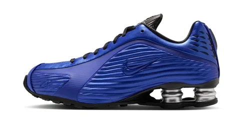 Chaussure de sport bleue à semelle noire et amortisseurs argentés