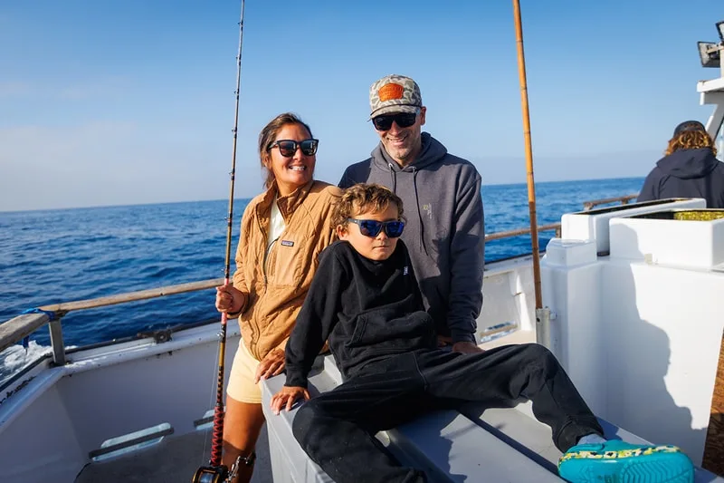 Famille pêchant en mer, homme, femme et enfant en lunettes de soleil.
