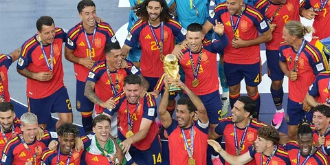 Joueurs de football en rouge célébrant avec un trophée