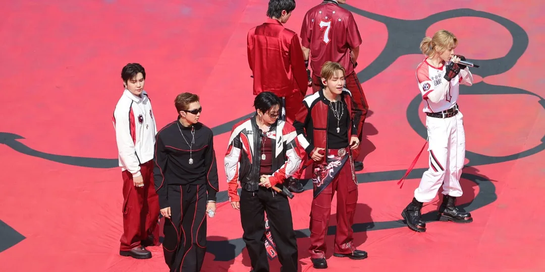 Groupe de personnes en tenue de performance rouge et blanche sur scène.