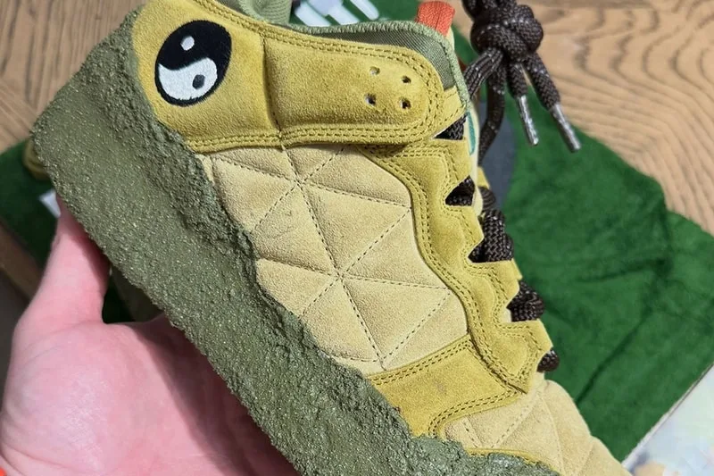 Chaussure beige avec symbole yin yang et semelle verte texturée