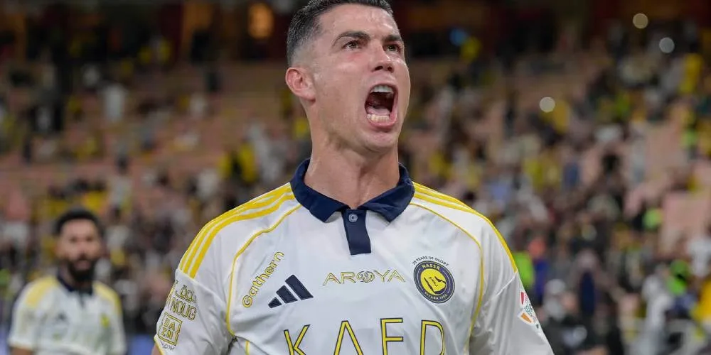 Joueur de football en maillot blanc criant sur le terrain.