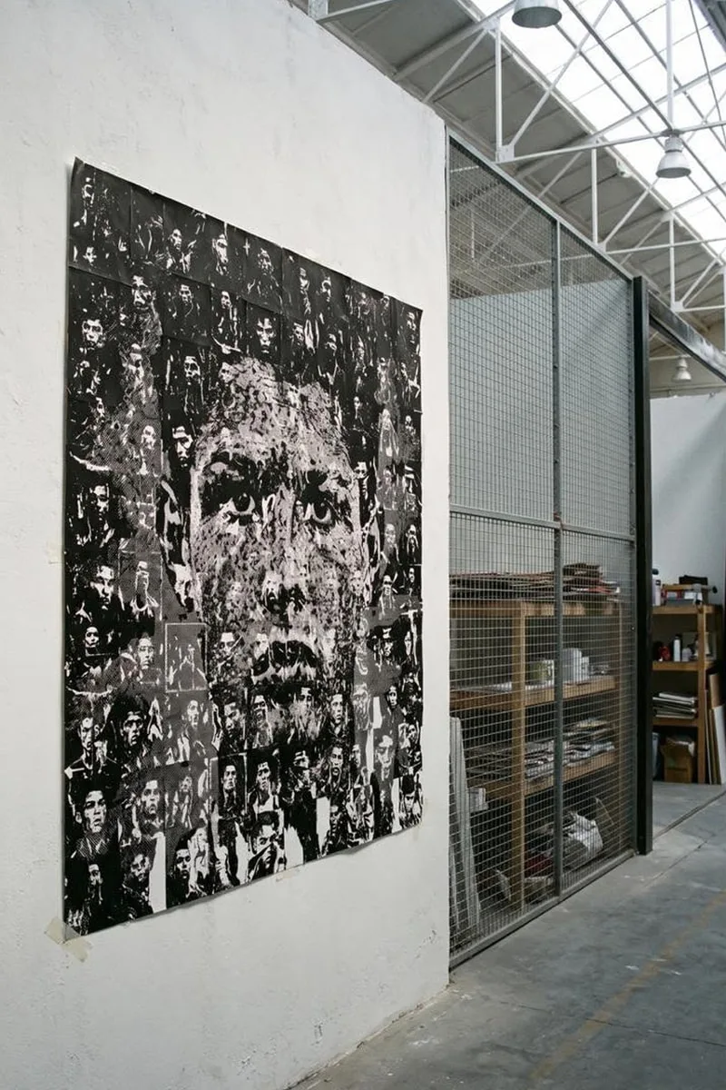 Collage en noir et blanc sur un mur dans un espace industriel lumineux.