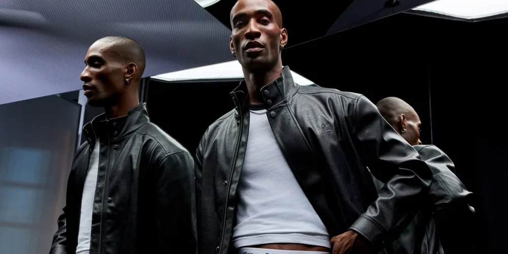 Trois hommes portent des vestes en cuir noir dans un décor moderne.