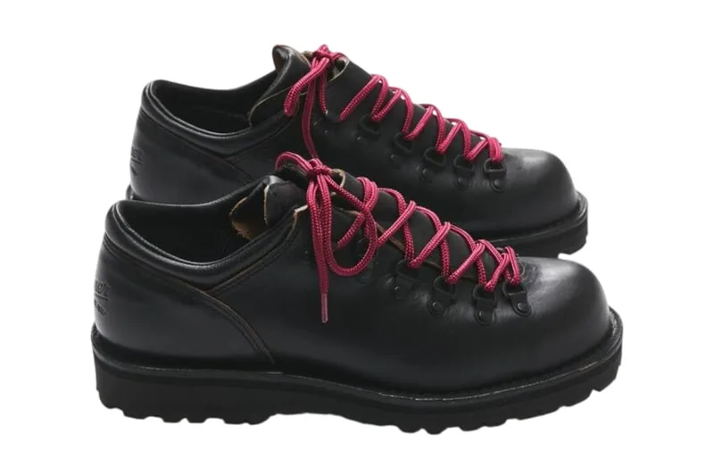 Chaussures de randonnée en cuir noir avec lacets rouges.