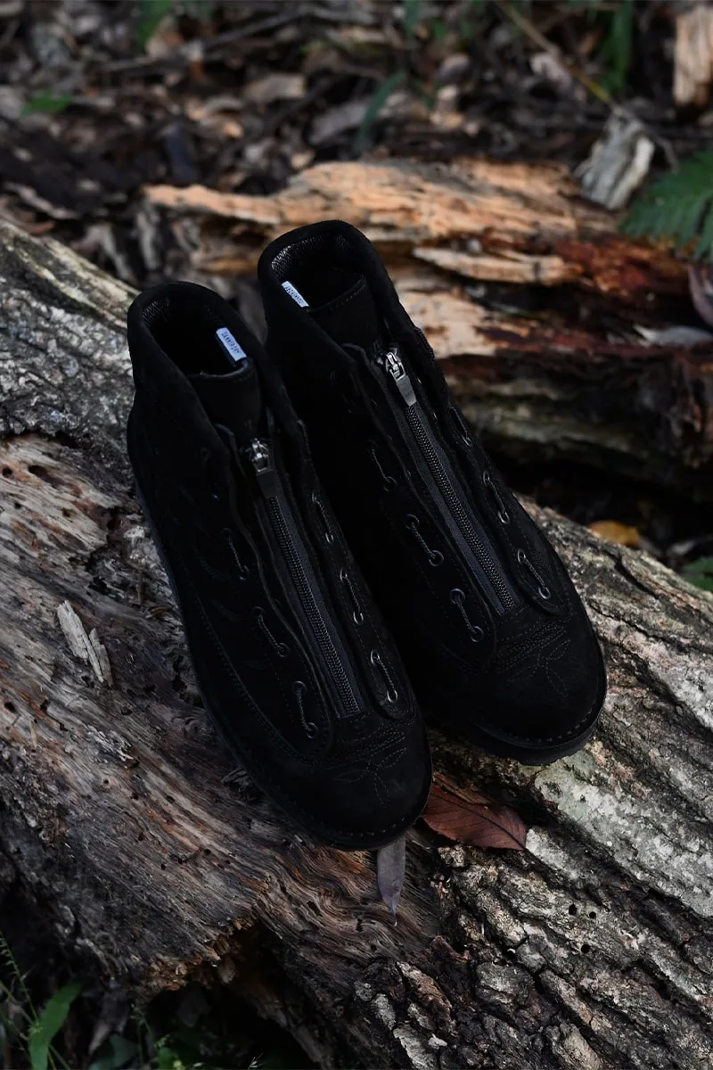 Chaussures noires sur du bois, prises en extérieur.