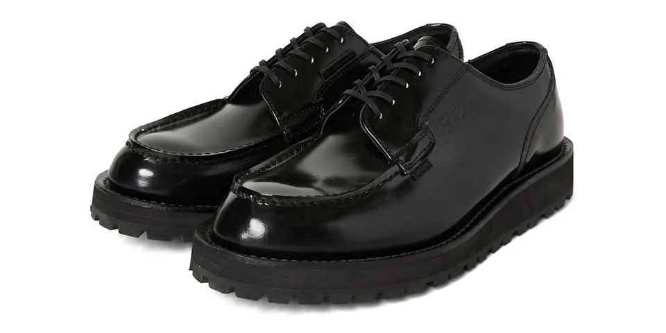 Chaussures noires brillantes avec semelle épaisse et lacets.