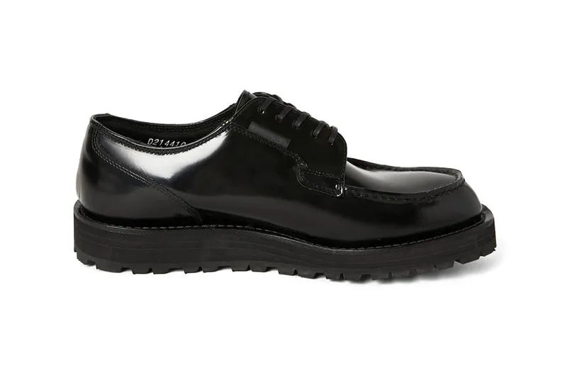 Chaussure derby en cuir verni noir avec semelle épaisse.