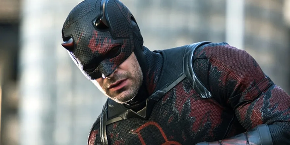Personnage en costume de super-héros noir et rouge.