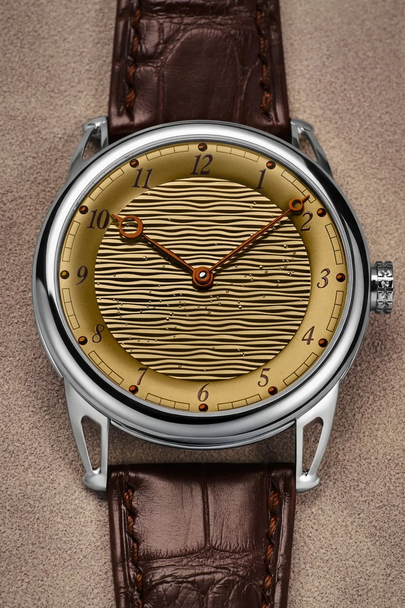 Montre avec cadran texturé et bracelet en cuir marron.