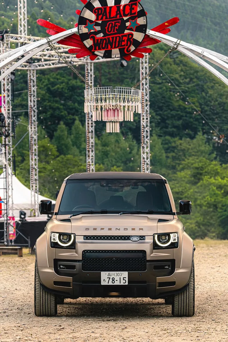 Voiture Defender devant une affiche 'Palace of Wonder'.