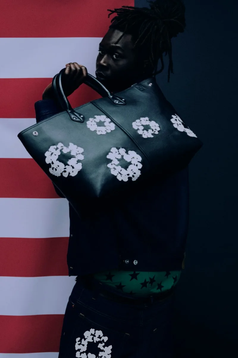 Homme avec sac noir et motif floral devant un fond rayé.