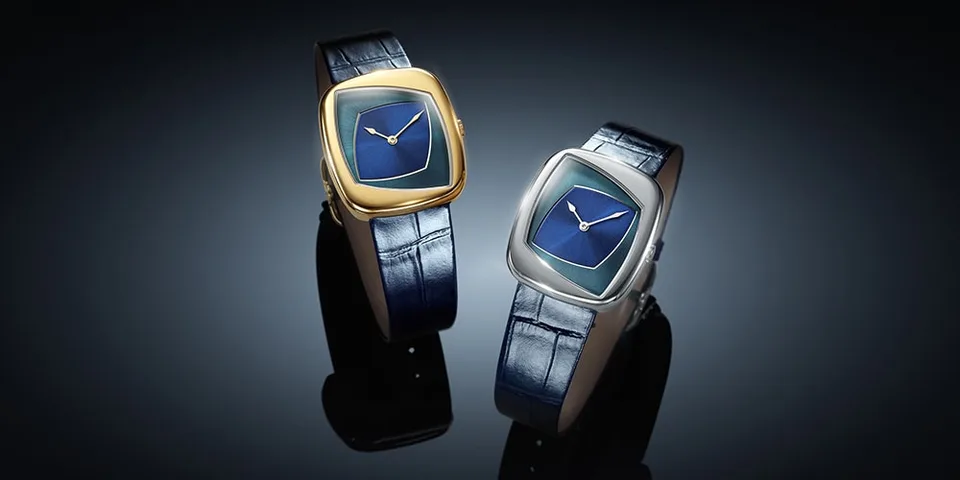 Deux montres avec bracelet en cuir bleu et cadran doré et argent sur fond noir.