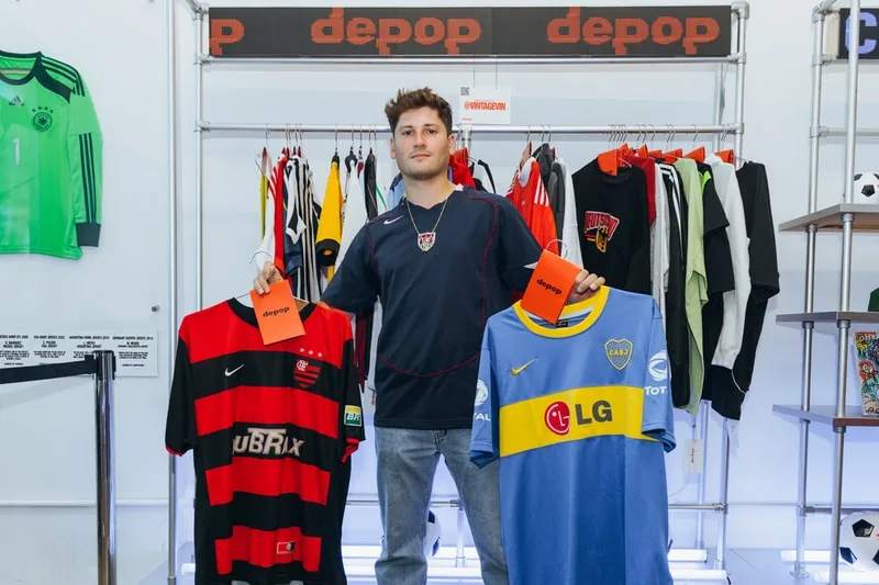 Homme tenant deux maillots de football rouge et bleu dans une boutique.
