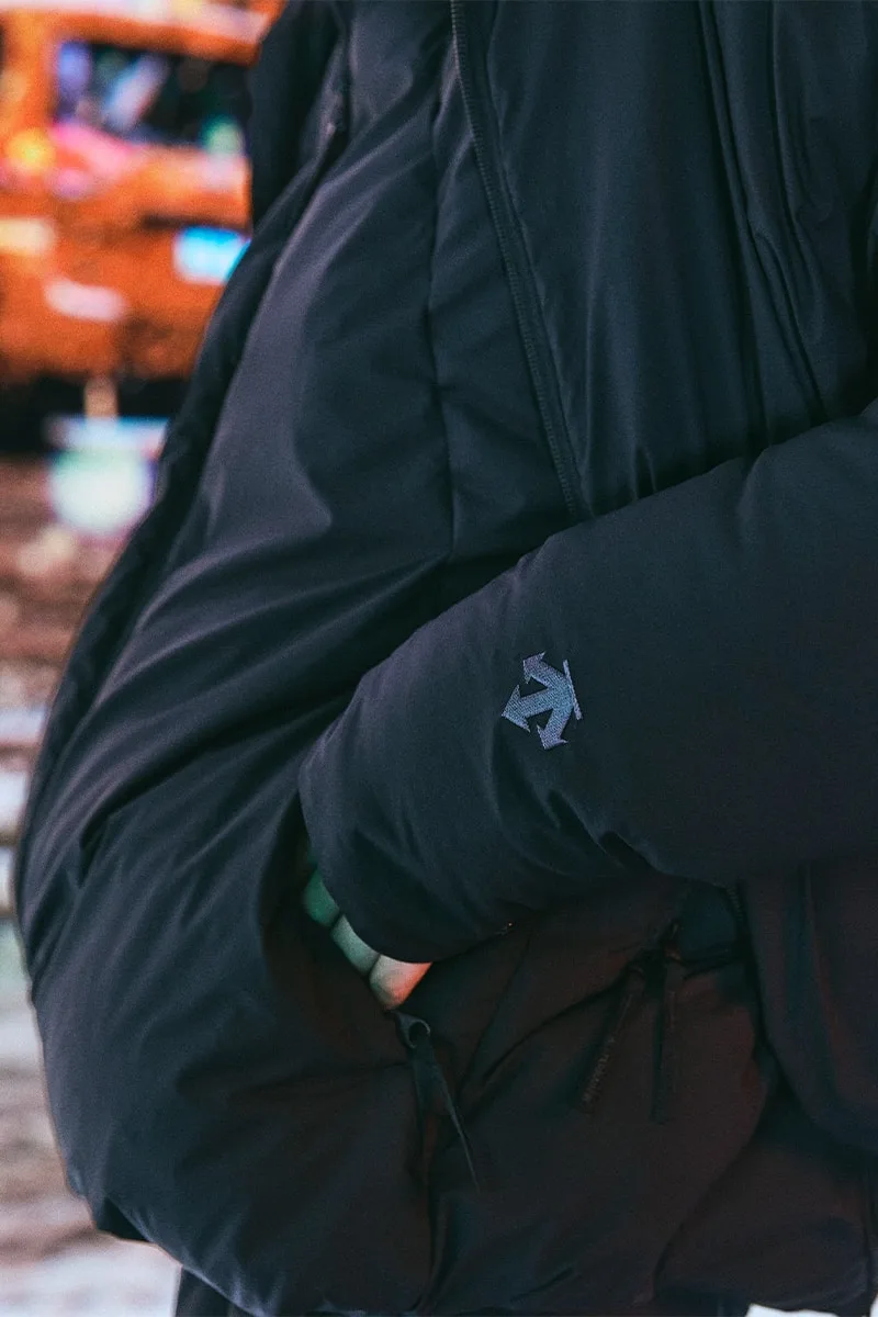 Personne portant une veste noire avec une flèche sur la manche.