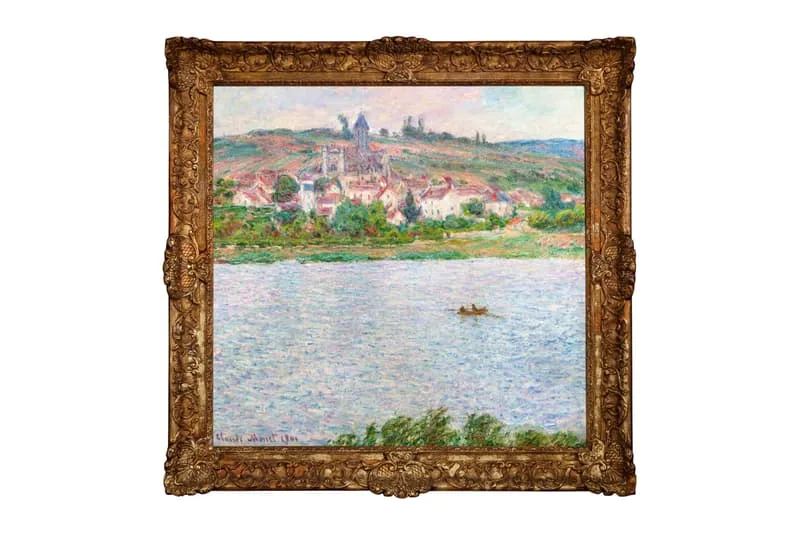 Peinture de paysage fluvial avec village en arrière-plan dans un cadre orné.
