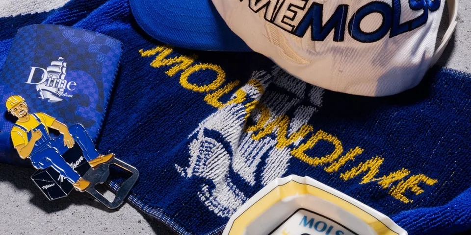 Casquette blanche et articles promotionnels sur surface grise.