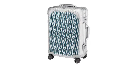 Valise argentée avec motif géométrique sur fond texturé.