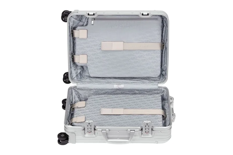 Valise ouverte avec sangles et doublure grise à motif.