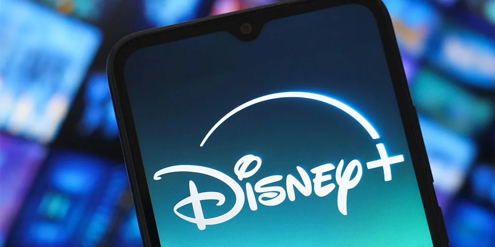 Logo Disney+ sur écran de smartphone, flou en arrière-plan