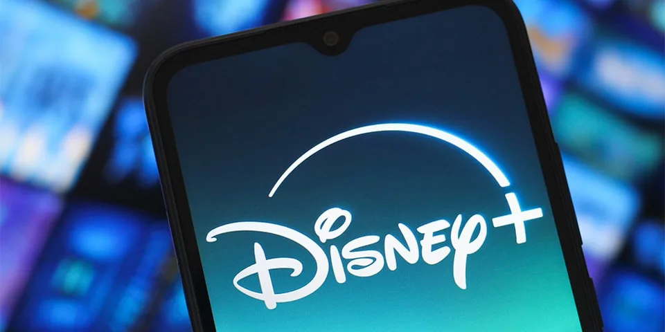 Logo Disney+ sur écran de smartphone, flou en arrière-plan
