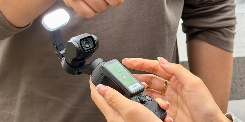 Deux personnes utilisant une caméra stabilisée avec lumière intégrée.