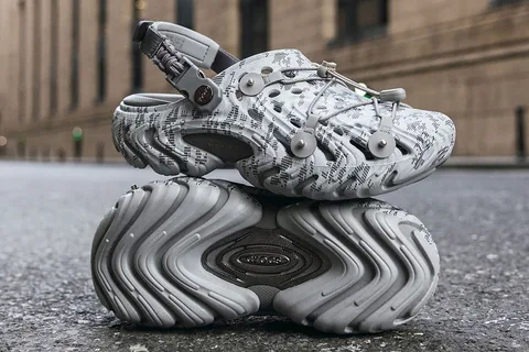 Chaussure futuriste grise posée sur une semelle sculpturale dans la rue.