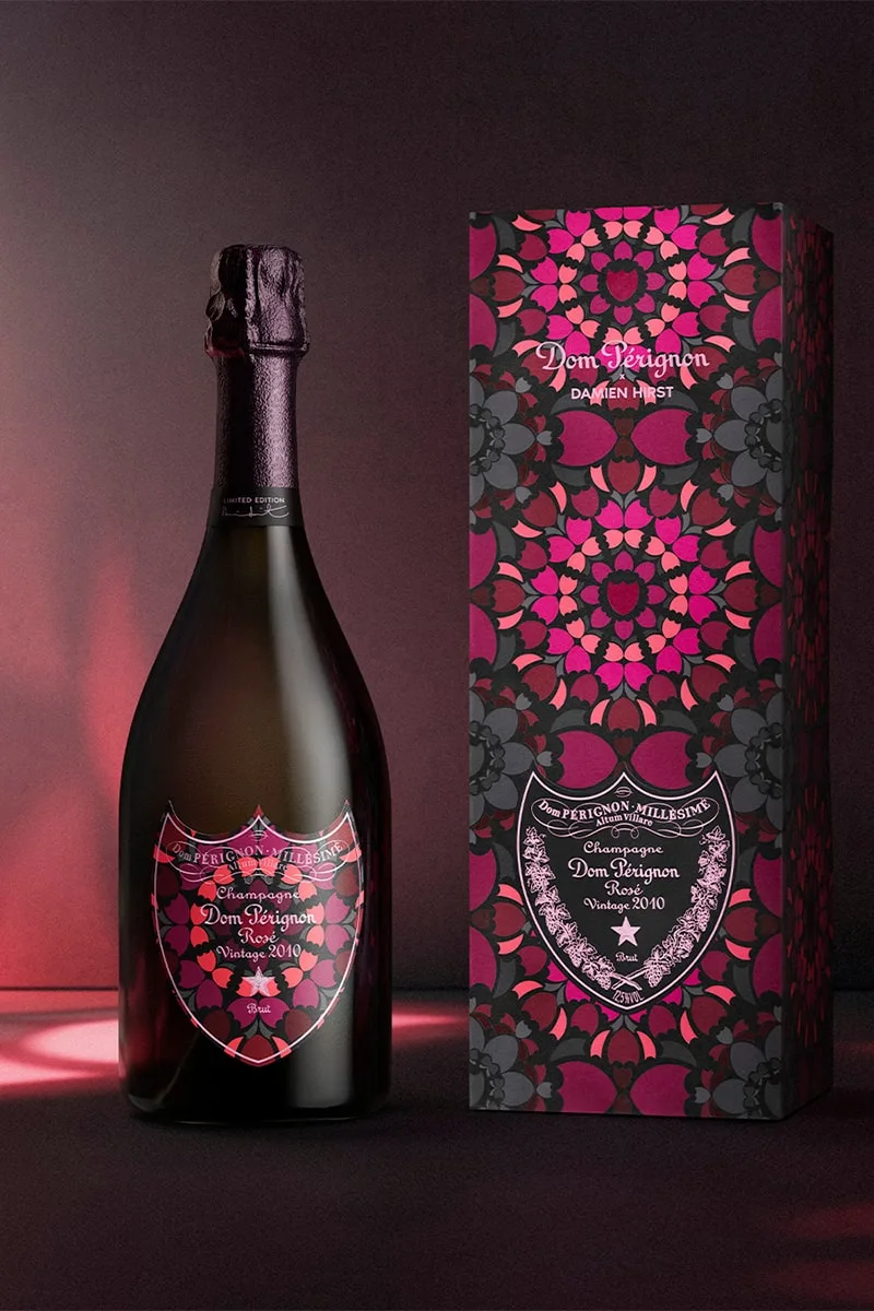 Bouteille de champagne avec boîte aux motifs floraux roses et noirs.