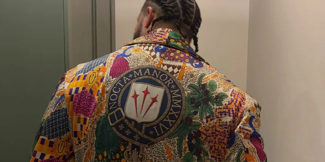 Personne avec veste colorée et cheveux tressés, dos tourné.