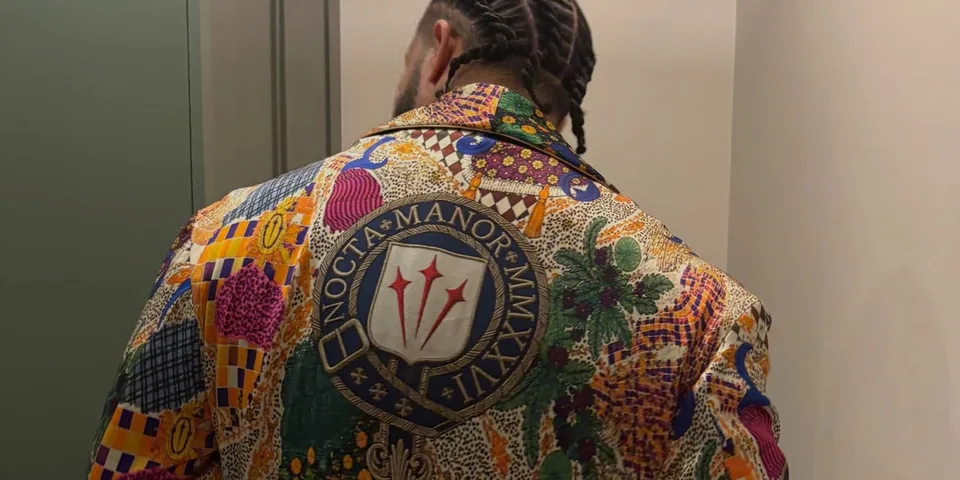 Personne avec veste colorée et cheveux tressés, dos tourné.