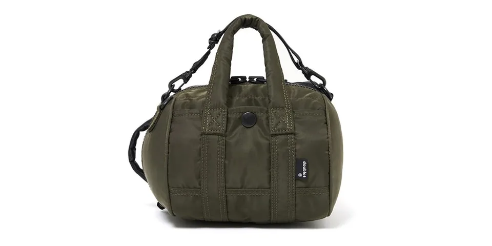 Petit sac à bandoulière vert kaki avec poignée et bandoulière ajustable.