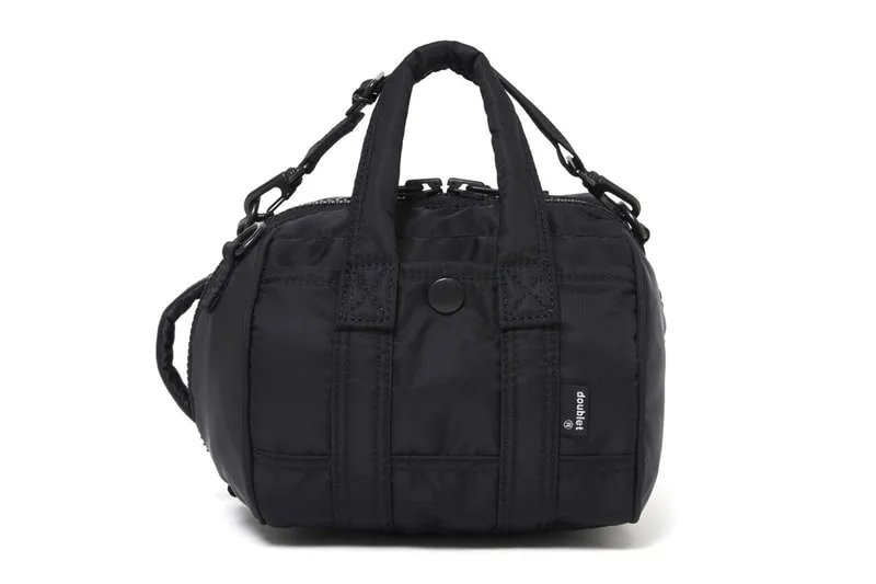 Petit sac noir avec poignées et bandoulière.