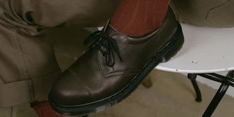Chaussure marron avec lacets sur fond neutre.