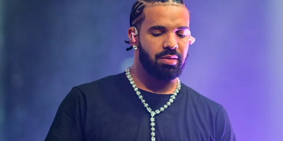 Homme barbu avec tresse et chaîne sur scène.