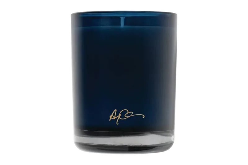 Bougie en verre bleu avec signature dorée à la base.