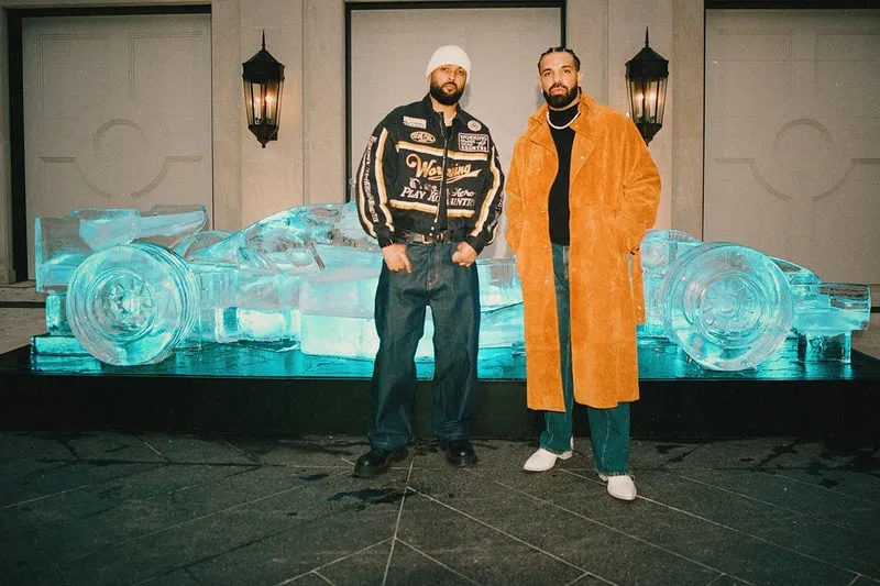 Deux personnes devant une sculpture de voiture en glace.