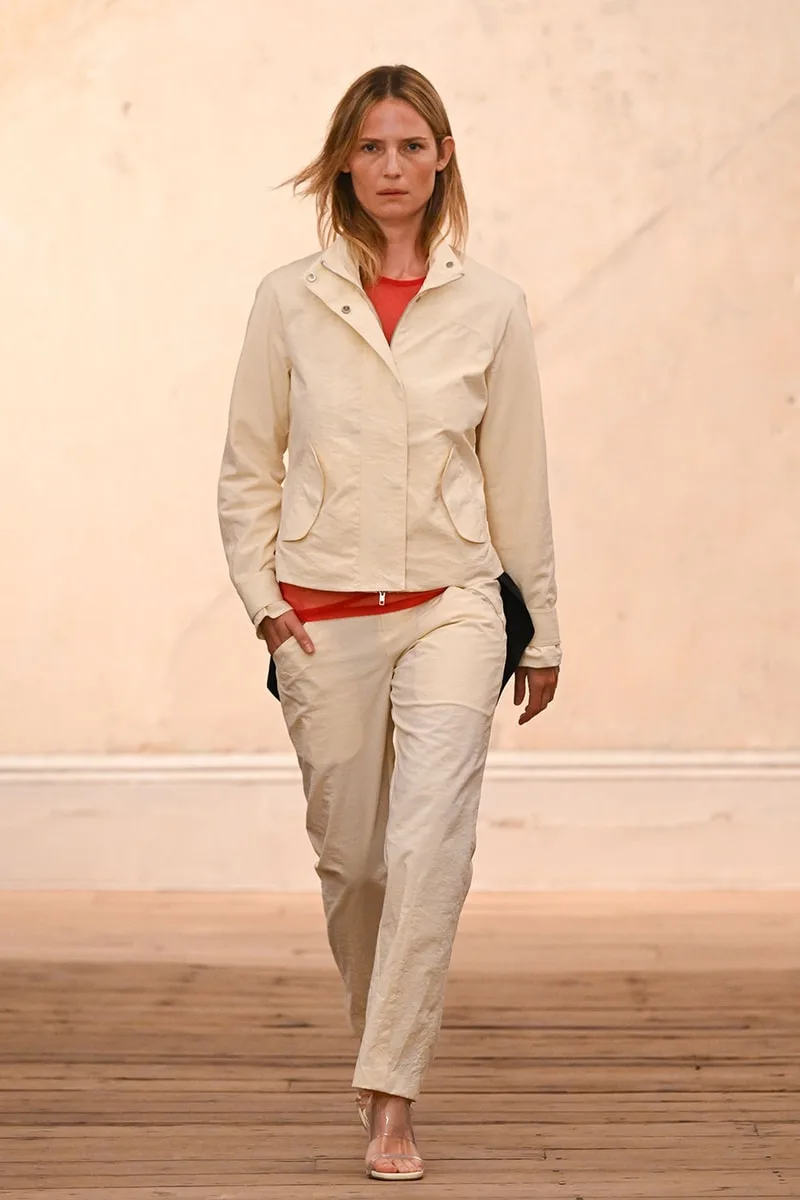 Femme défilant en tenue crème sur fond beige