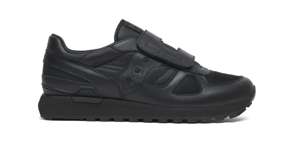 Chaussure noire avec fermeture à scratch et semelle texturée.