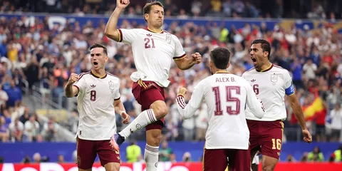 Joueurs de football célébrant un but lors d'un match.