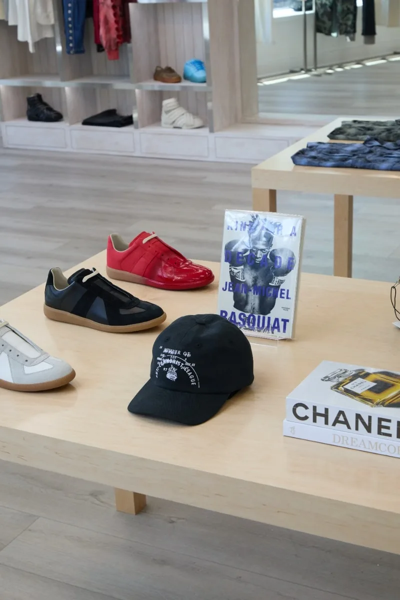 Chaussures et livres exposés sur une table dans un magasin de mode.