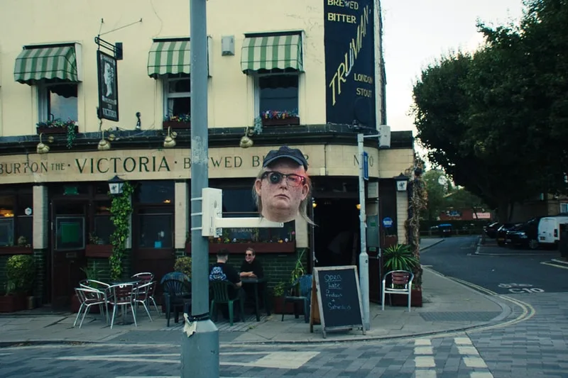 Bar anglais avec photo flottante d'une personne sur le côté de la rue.
