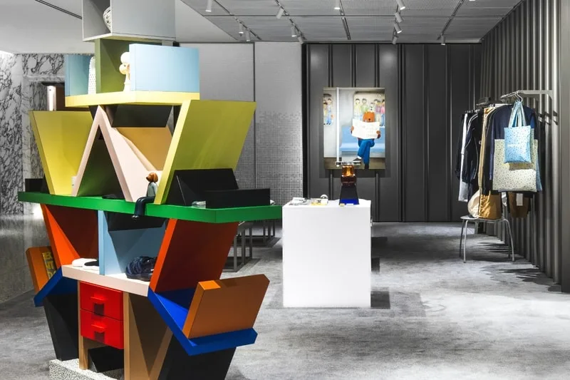 Intérieur moderne avec étagère colorée et vêtements exposés.