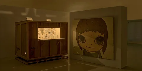 Exposition artistique avec boîte en bois et peinture d'un visage.