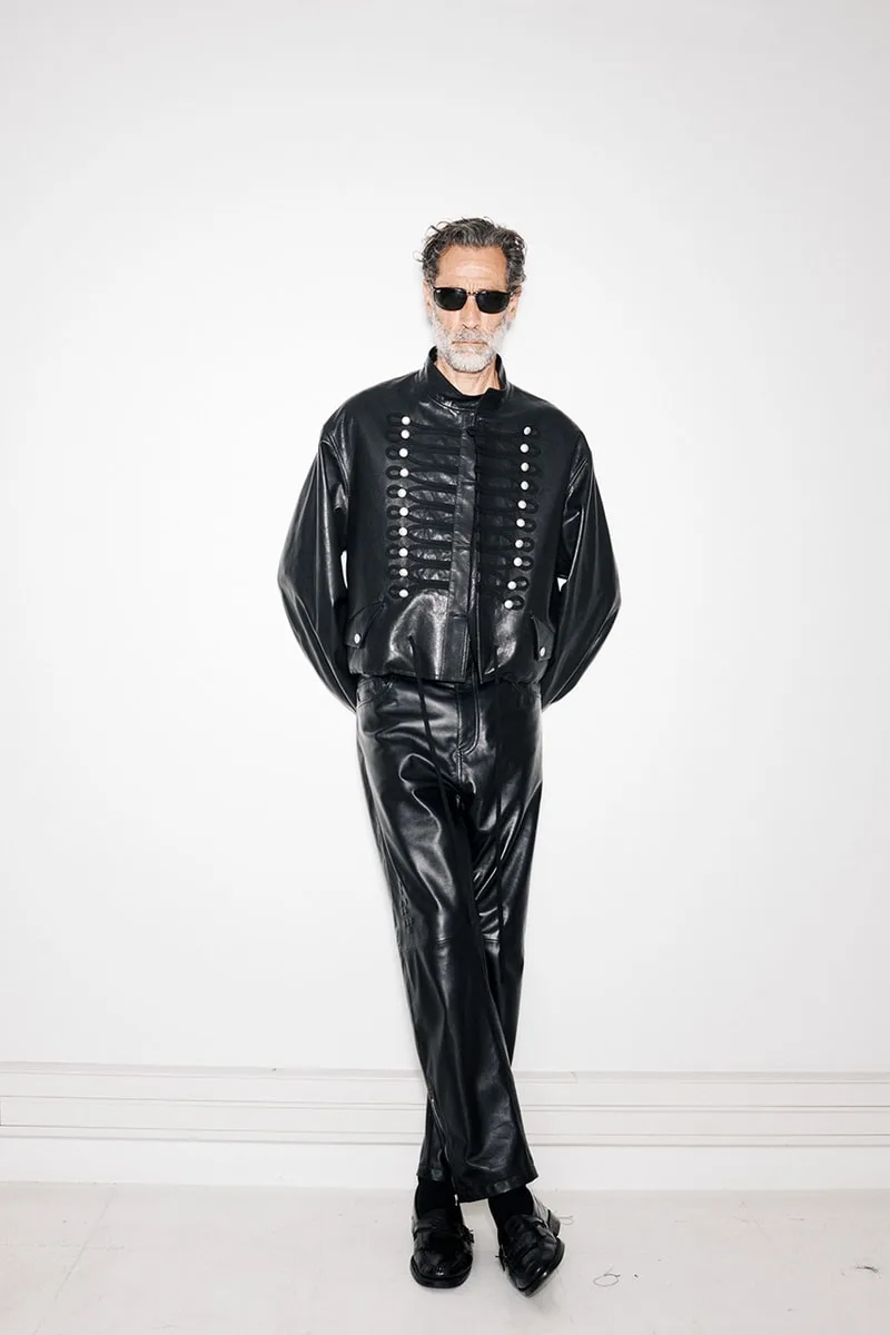 Homme en vêtements noirs élégants avec lunettes de soleil.