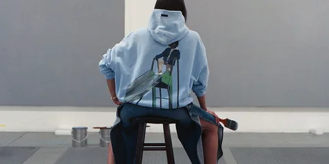 Personne assise avec un sweat à capuche imprimé