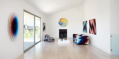 Salon moderne avec canapé multicolore et œuvres d'art vibrantes aux murs.