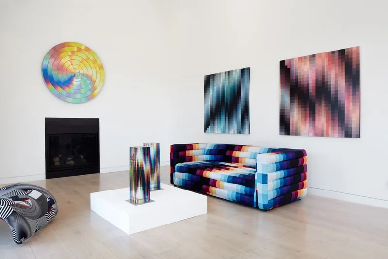 Salon moderne avec canapés aux motifs colorés et œuvres d'art abstraites sur les murs.