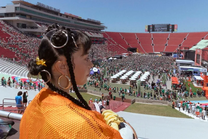 Femme regardant un stade plein de gens lors d'un événement sportif.
