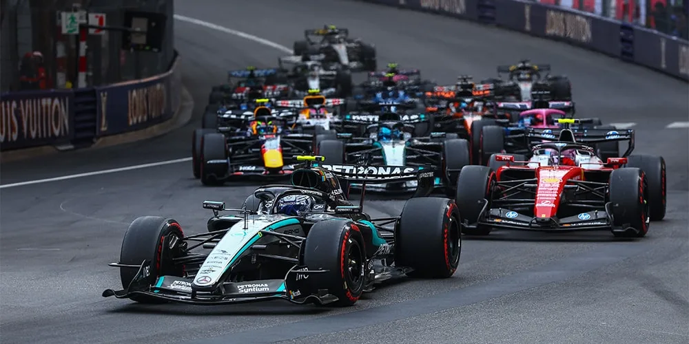 Course de voitures de Formule 1 avec plusieurs voitures sur la piste.