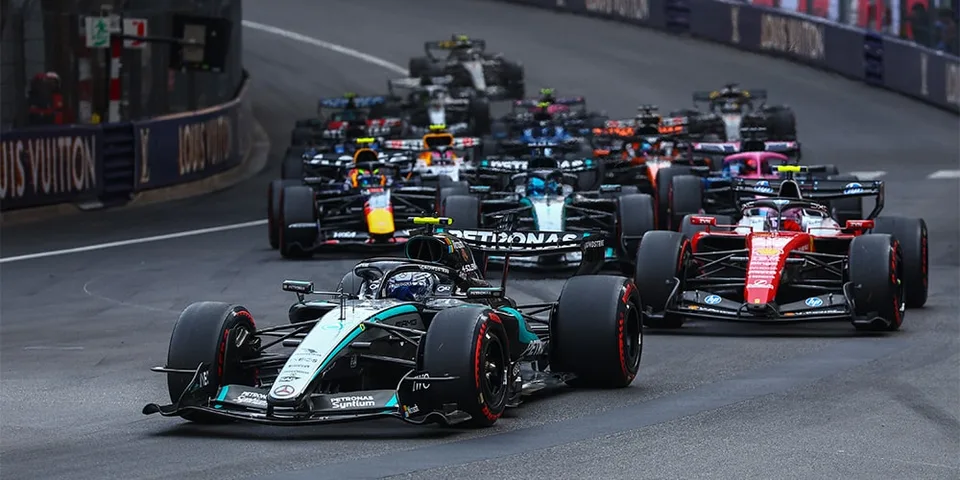 Course de voitures de Formule 1 avec plusieurs voitures sur la piste.